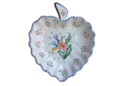 A fruit shaped ceramic baking or serving dish hand painted with flowers and star-like designs accented by blue and gray dabs of color around the wavy rim from Keramik.  The dish measures 9 1/4" across, 11 3/8" tall, and 1 1/2" high.  The bottom is impressed with "Laholms-Keramik Ugnseldfast Made in Sweden" and the markings "408 Q."  The dish has some light spidering to the finish but is otherwise in good original condition.