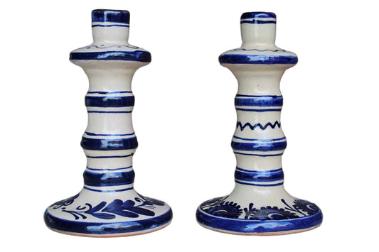 A pair of ceramic candlesticks from Arta Aplicata featuring unique hand-painted floral designs on both, each slightly different.  Each candlestick measures 4 1/8" across the base and 6 3/4" tall.  The bottoms are marked with the original paper stickers (1 is torn" and the condition of both is very good.