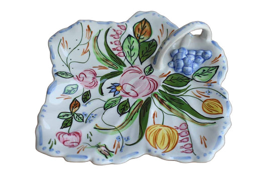 A ceramic leaf-shaped celery or tidbit tray from Blue Ridge China featuring a riot of colorful hand-painted flowers and finished with a little handle and raised grape decoration.  The tray measures 10" long, 9 3/4" wide and 2" high.  The bottom is marked "Blue Ridge China Hand Painted Underglaze Southern Galleries Inc. Made in U.S."  The condition is good.  There are two tiny no-show chips to the rim on the underside.